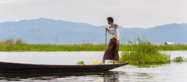 Inle Lake, Myanmar - 30 Ağustos 2016: Myanmar'ın Shan Eyaletinin Taunggyi İlçesi'nin Nyaungshwe İlçesi'nde bulunan bir tatlı su gölü olan Inle Sap'ın üzerinde bambu teknede bulunan tanımlanamayan Birmanyalı adam