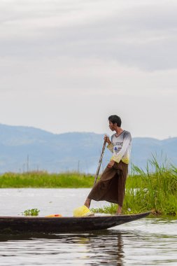 Inle Lake, Myanmar - 30 Ağustos 2016: Myanmar'ın Shan Eyaletinin Taunggyi İlçesi'nin Nyaungshwe İlçesi'nde bulunan bir tatlı su gölü olan Inle Sap'ın üzerinde bambu teknede bulunan tanımlanamayan Birmanyalı adam