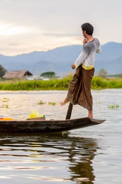 Inle Lake, Myanmar - 30 Ağustos 2016: Myanmar'ın Shan Eyaletinin Taunggyi İlçesi'nin Nyaungshwe İlçesi'nde bulunan bir tatlı su gölü olan Inle Sap'ın üzerinde bambu teknede bulunan tanımlanamayan Birmanyalı adam