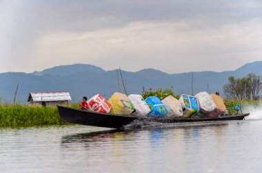 Inle Lake, Myanmar - 30 Ağustos 2016: Shan Eyaleti'nin Taunggyi İlçesi Nyaungshwe İlçesi'nde bulunan bir tatlı su gölü olan Inle Sap'ın üzerinde çantalı bambu teknede tanımlanamayan Birmanyalı adam