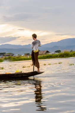 Inle Lake, Myanmar - 30 Ağustos 2016: Myanmar'ın Shan Eyaletinin Taunggyi İlçesi'nin Nyaungshwe İlçesi'nde bulunan bir tatlı su gölü olan Inle Sap'ın üzerinde bambu teknede bulunan tanımlanamayan Birmanyalı adam