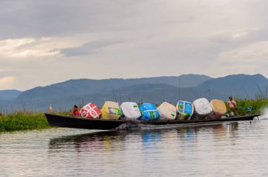 Inle Lake, Myanmar - 30 Ağustos 2016: Shan Eyaleti'nin Taunggyi İlçesi Nyaungshwe İlçesi'nde bulunan bir tatlı su gölü olan Inle Sap'ın üzerinde çantalı bambu teknede tanımlanamayan Birmanyalı adam