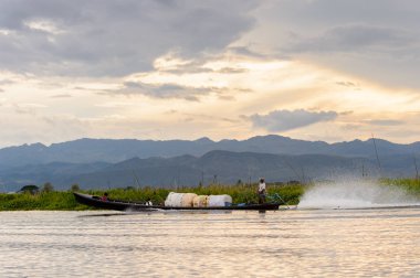 Inle Lake, Myanmar - 30 Ağustos 2016: Shan Eyaleti'nin Taunggyi İlçesi Nyaungshwe İlçesi'nde bulunan bir tatlı su gölü olan Inle Sap'ın üzerinde çantalı bambu teknede tanımlanamayan Birmanyalı adam