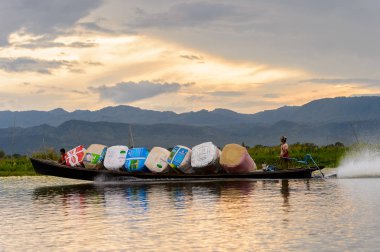 Inle Lake, Myanmar - 30 Ağustos 2016: Shan Eyaleti'nin Taunggyi İlçesi Nyaungshwe İlçesi'nde bulunan bir tatlı su gölü olan Inle Sap'ın üzerinde çantalı bambu teknede tanımlanamayan Birmanyalı adam