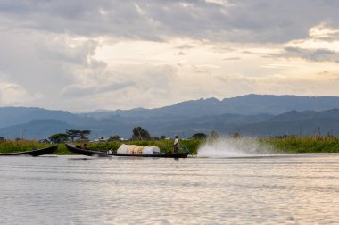 Inle Lake, Myanmar - 30 Ağustos 2016: Shan Eyaleti'nin Taunggyi İlçesi Nyaungshwe İlçesi'nde bulunan bir tatlı su gölü olan Inle Sap'ın üzerinde çantalı bambu teknede tanımlanamayan Birmanyalı adam