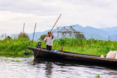 Inle Lake, Myanmar - 30 Ağustos 2016: Myanmar'ın Shan Eyaletinin Taunggyi İlçesi'nin Nyaungshwe İlçesi'nde bulunan bir tatlı su gölü olan Inle Sap'ın üzerinde bambu teknede bulunan tanımlanamayan Birmanyalı adam