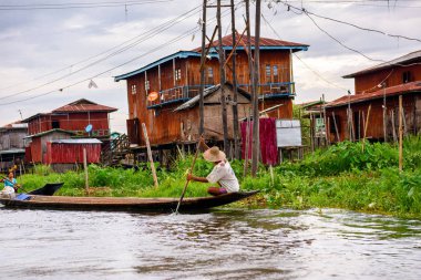 Inle Lake, Myanmar - 30 Ağustos 2016: Shan Eyaleti'nin Taunggyi İlçesi Nyaungshwe İlçesi'nde bulunan bir tatlı su gölü olan Inle Sap'ın üzerinde çantalı bambu teknede tanımlanamayan Birmanyalı adam