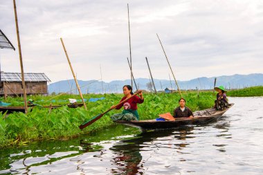 Inle Lake, Myanmar - 30 Ağustos 2016: Myanmar'ın Shan Eyaletinin Taunggyi İlçesi'nin Nyaungshwe İlçesi'nde bulunan bir tatlı su gölü olan Inle Sap'ın üzerinde bambu teknede bulunan tanımlanamayan Birmanyalı kadın