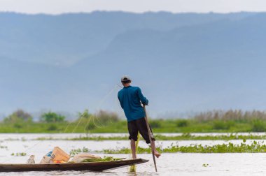 Inle Lake, Myanmar - 30 Ağustos 2016: Myanmar'ın Shan Eyaletinin Taunggyi İlçesi'nin Nyaungshwe İlçesi'nde bulunan bir tatlı su gölü olan Inle Sap'ın üzerinde bambu teknede bulunan tanımlanamayan Birmanyalı adam