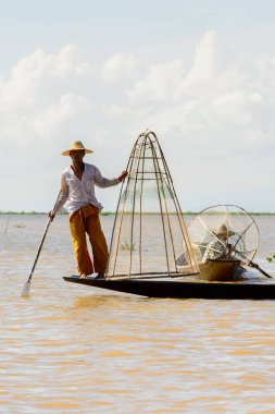 Inle Lake, Myanmar - 30 Ağustos 2016: Özel el yapımı ağı olan bir teknede tanımlanamayan Birmanyalı balıkçı. Bu Myanmar balıkçılık geleneksel yoludur