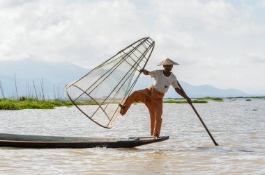 Inle Lake, Myanmar - 30 Ağustos 2016: Özel el yapımı ağı olan bir teknede tanımlanamayan Birmanyalı balıkçı. Bu Myanmar balıkçılık geleneksel yoludur