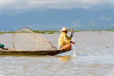 Inle Lake, Myanmar - 30 Ağustos 2016: Özel el yapımı ağı olan bir teknede tanımlanamayan Birmanyalı balıkçı. Bu Myanmar balıkçılık geleneksel yoludur