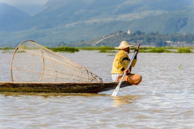 Inle Lake, Myanmar - 30 Ağustos 2016: Özel el yapımı ağı olan bir teknede tanımlanamayan Birmanyalı balıkçı. Bu Myanmar balıkçılık geleneksel yoludur