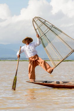 Inle Lake, Myanmar - 30 Ağustos 2016: Özel el yapımı ağı olan bir teknede tanımlanamayan Birmanyalı balıkçı. Bu Myanmar balıkçılık geleneksel yoludur