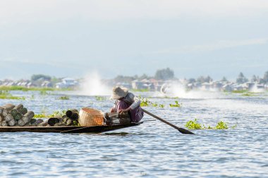 Inle Lake, Myanmar - 30 Ağustos 2016: Myanmar'ın Shan Eyaletinin Taunggyi İlçesi'nin Nyaungshwe İlçesi'nde bulunan bir tatlı su gölü olan Inle Sap'ın üzerinde bambu teknede bulunan tanımlanamayan Birmanyalı adam