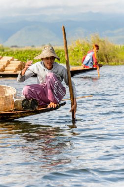 Inle Lake, Myanmar - 30 Ağustos 2016: Myanmar'ın Shan Eyaletinin Taunggyi İlçesi'nin Nyaungshwe İlçesi'nde bulunan bir tatlı su gölü olan Inle Sap'ın üzerinde bambu teknede bulunan tanımlanamayan Birmanyalı adam