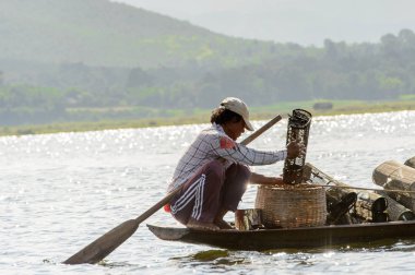 Inle Lake, Myanmar - 30 Ağustos 2016: Myanmar'ın Shan Eyaletinin Taunggyi İlçesi'nin Nyaungshwe İlçesi'nde bulunan bir tatlı su gölü olan Inle Sap'ın üzerinde bambu teknede bulunan tanımlanamayan Birmanyalı adam