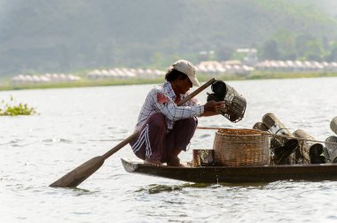 Inle Lake, Myanmar - 30 Ağustos 2016: Myanmar'ın Shan Eyaletinin Taunggyi İlçesi'nin Nyaungshwe İlçesi'nde bulunan bir tatlı su gölü olan Inle Sap'ın üzerinde bambu teknede bulunan tanımlanamayan Birmanyalı adam