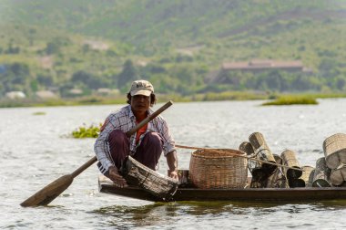 Inle Lake, Myanmar - 30 Ağustos 2016: Myanmar'ın Shan Eyaletinin Taunggyi İlçesi'nin Nyaungshwe İlçesi'nde bulunan bir tatlı su gölü olan Inle Sap'ın üzerinde bambu teknede bulunan tanımlanamayan Birmanyalı adam