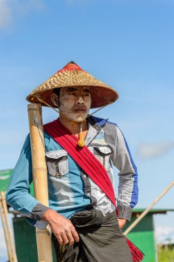 Inle Lake, Myanmar - 30 Ağustos 2016: Ahşap bir teknede tanımlanamayan Birmanyalı adam. Myanma halkının yüzde 68'i Bamar etnik grubuna mensandı