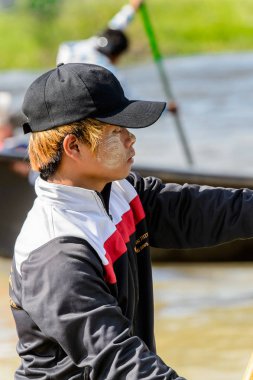 Inle Lake, Myanmar - 30 Ağustos 2016: Inle Gölü üzerinde ahşap bir teknede tanımlanamayan Birmanyalı çocuk. Myanma halkının yüzde 68'i Bamar etnik grubuna mensandı