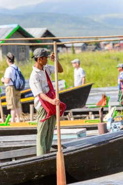 Inle Lake, Myanmar - 30 Ağustos 2016: Inle Gölü üzerinde ahşap bir teknede tanımlanamayan Birmanyalı adam. Myanma halkının yüzde 68'i Bamar etnik grubuna mensandı