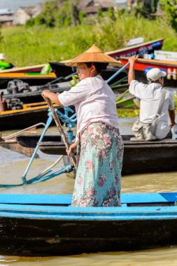 Inle Lake, Myanmar - 30 Ağustos 2016: Inle Gölü üzerinde ahşap bir teknede tanımlanamayan Birmanyalı kadın. Myanma halkının yüzde 68'i Bamar etnik grubuna mensandı