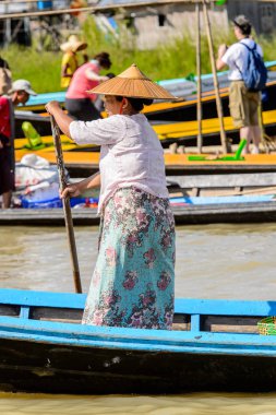 Inle Lake, Myanmar - 30 Ağustos 2016: Inle Gölü üzerinde ahşap bir teknede tanımlanamayan Birmanyalı kadın. Myanma halkının yüzde 68'i Bamar etnik grubuna mensandı