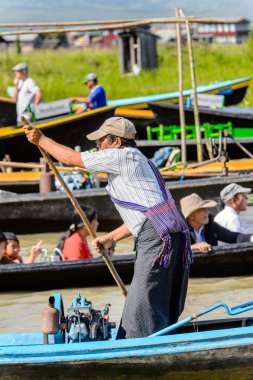Inle Lake, Myanmar - 30 Ağustos 2016: Inle Gölü üzerinde ahşap bir teknede tanımlanamayan Birmanyalı adam. Myanma halkının yüzde 68'i Bamar etnik grubuna mensandı