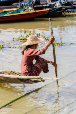 Inle Lake, Myanmar - 30 Ağustos 2016: Tanımlanamayan Birmanyalı kadın Inle Gölü üzerinde ahşap bir tekne sıralıyor. Myanma halkının yüzde 68'i Bamar etnik grubuna mensandı