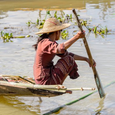 Inle Lake, Myanmar - 30 Ağustos 2016: Tanımlanamayan Birmanyalı kadın Inle Gölü üzerinde ahşap bir tekne sıralıyor. Myanma halkının yüzde 68'i Bamar etnik grubuna mensandı