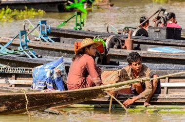Inle Lake, Myanmar - 30 Ağustos 2016: Shan Eyaleti'nin Taunggyi İlçesi Nyaungshwe İlçesi'nde bulunan bir tatlı su gölü olan Inle Sap üzerinde bambu teknesinde tanımlanamayan Birmanyalı kadın,
