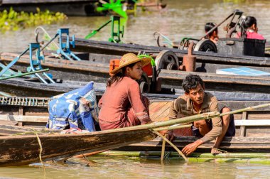 Inle Lake, Myanmar - 30 Ağustos 2016: Shan Eyaleti'nin Taunggyi İlçesi Nyaungshwe İlçesi'nde bulunan bir tatlı su gölü olan Inle Sap üzerinde bambu teknesinde tanımlanamayan Birmanyalı kadın,