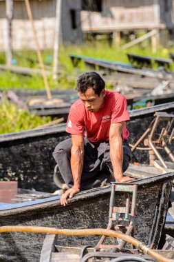 Inle Lake, Myanmar - 30 Ağustos 2016: Shan Eyaleti'nin Taunggyi İlçesi Nyaungshwe İlçesi'nde bulunan bir tatlı su gölü olan Inle Sap üzerinde bambu teknesinde tanımlanamayan Birmanyalı adam,