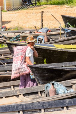 Inle Lake, Myanmar - 30 Ağustos 2016: Shan Eyaleti'nin Taunggyi İlçesi Nyaungshwe İlçesi'nde bulunan bir tatlı su gölü olan Inle Sap üzerinde bambu teknesinde tanımlanamayan Birmanyalı adam,