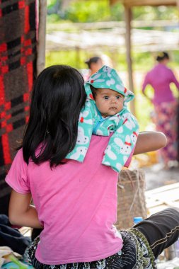 Inle Lake, Myanmar - 30 Ağustos 2016: Çocuğuyla birlikte kimliği belirsiz Birmanyalı kadın. Myanma halkının yüzde 68'i Bamar etnik grubuna mensandı
