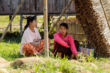 Inle Lake, Myanmar - 30 Ağustos 2016: Tanımlanamayan Birmanyalı kadınlar çimlerin üzerinde oturacak. Myanma halkının yüzde 68'i Bamar etnik grubuna mensandı