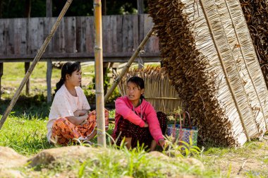 Inle Lake, Myanmar - 30 Ağustos 2016: Tanımlanamayan Birmanyalı kadınlar çimlerin üzerinde oturacak. Myanma halkının yüzde 68'i Bamar etnik grubuna mensandı