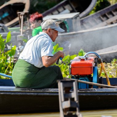 Inle Lake, Myanmar - 30 Ağustos 2016: Myanmar'ın Shan Eyaletinin Taunggyi İlçesi'nin Nyaungshwe İlçesi'nde bulunan bir tatlı su gölü olan Inle Sap'ın üzerinde bambu teknede bulunan tanımlanamayan Birmanyalı adam