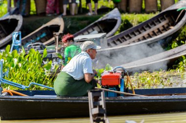 Inle Lake, Myanmar - 30 Ağustos 2016: Myanmar'ın Shan Eyaletinin Taunggyi İlçesi'nin Nyaungshwe İlçesi'nde bulunan bir tatlı su gölü olan Inle Sap'ın üzerinde bambu teknede bulunan tanımlanamayan Birmanyalı adam