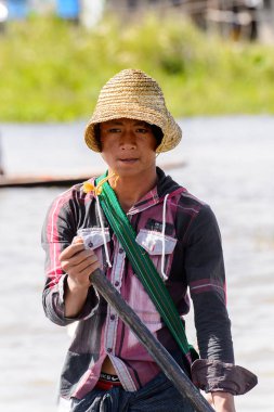 Inle Lake, Myanmar - 30 Ağustos 2016: Tanımlanamayan Birmanyalı çocuk ahşap bir tekneyi çiğyapıyor. Myanma halkının yüzde 68'i Bamar etnik grubuna mensandı
