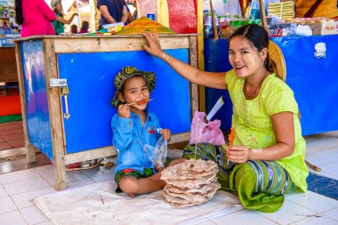 Inle Lake, Myanmar - 30 Ağustos 2016: Küçük çocuğuyla birlikte kimliği belirsiz bir manyalı kız. Myanma halkının yüzde 68'i Bamar etnik grubuna mensandı