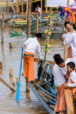 Inle Lake, Myanmar - 30 Ağustos 2016: Inle Gölü'nün iskelesinde ahşap bir tekne ile tanımlanamayan Birmanya çocuk. Myanma halkının yüzde 68'i Bamar etnik grubuna mensandı