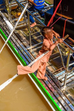 Inle Lake, Myanmar - 30 Ağustos 2016: İnle Gölü'nde ahşap bir teknede tanımlanamayan Birmanyalı çocuk. Myanma halkının yüzde 68'i Bamar etnik grubuna mensandı