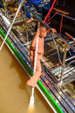 Inle Lake, Myanmar - 30 Ağustos 2016: İnle Gölü'nde ahşap bir teknede tanımlanamayan Birmanyalı çocuk. Myanma halkının yüzde 68'i Bamar etnik grubuna mensandı