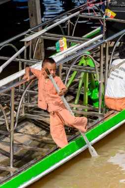 Inle Lake, Myanmar - 30 Ağustos 2016: Ahşap bir teknede tanımlanamayan Birmanyalı küçük çocuk. Myanma halkının yüzde 68'i Bamar etnik grubuna mensandı