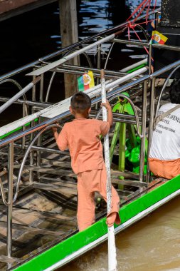 Inle Lake, Myanmar - 30 Ağustos 2016: Ahşap bir teknede tanımlanamayan Birmanyalı küçük çocuk. Myanma halkının yüzde 68'i Bamar etnik grubuna mensandı