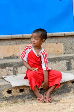 Inle Lake, Myanmar - 30 Ağustos 2016: Kırmızı gömlekli tanımlanamayan Birmanya lı küçük gitl. Myanma halkının yüzde 68'i Bamar etnik grubuna mensandı