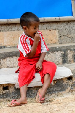 Inle Lake, Myanmar - 30 Ağustos 2016: Kırmızı gömlekli tanımlanamayan Birmanya lı küçük gitl. Myanma halkının yüzde 68'i Bamar etnik grubuna mensandı