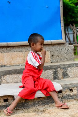 Inle Lake, Myanmar - 30 Ağustos 2016: Kırmızı gömlekli tanımlanamayan Birmanya lı küçük gitl. Myanma halkının yüzde 68'i Bamar etnik grubuna mensandı
